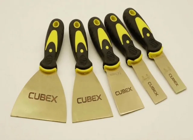 Cinco espátulas antifaiscantes CUBEX em liga de bronze, com cabos emborrachados, em larguras diferentes.